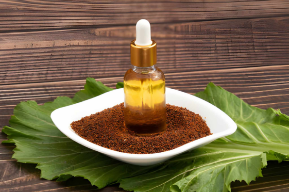 Glass dropper of mustard oil placed on ground mustard seeds.